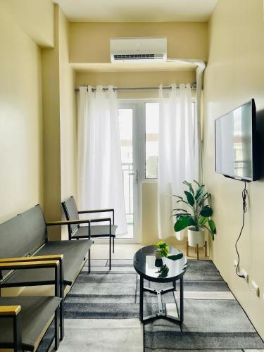 a living room with a couch and a tv at Avida Towers Atria in Iloilo City