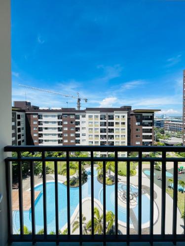 a balcony with a view of a pool and buildings at Avida Towers Atria in Iloilo City
