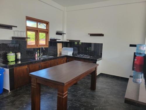 a kitchen with a wooden table in a room at captain mirissa in Mirissa