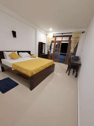 a bedroom with a bed with a yellow bedspread at captain mirissa in Mirissa