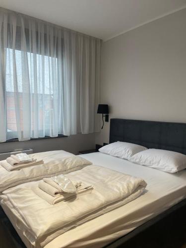 a bedroom with two beds with towels and a window at Moaline Apartments, free parking in Sarajevo