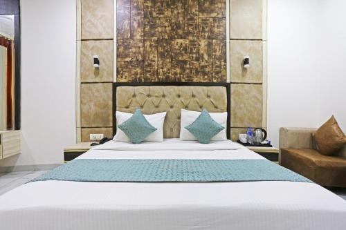 a bedroom with a large bed and a chair at HOTEL SHYAM INTERNATIONAL - NEAR TERMINAL 3 DELHI AIRPORT WITH - Free AIRPORT PICKUP in New Delhi
