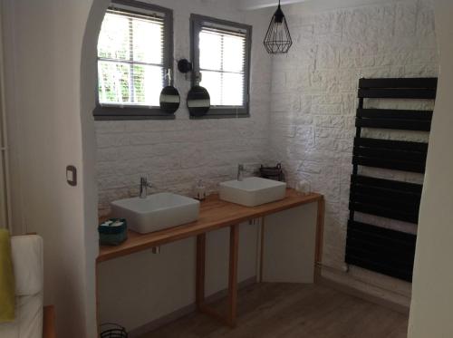 - une salle de bains avec deux lavabos sur un comptoir en bois dans l'établissement La Landaise propriété familiale, piscine chauffée, à Galgon