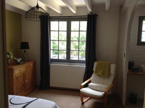 - une chambre avec une chaise et une fenêtre dans l'établissement La Landaise propriété familiale, piscine chauffée, à Galgon