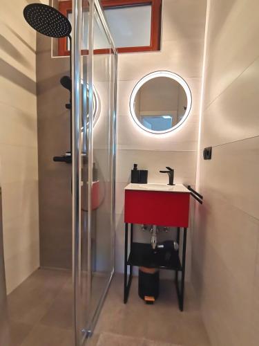 a bathroom with a red sink and a mirror at Landhaus Mitsche in Hermagor