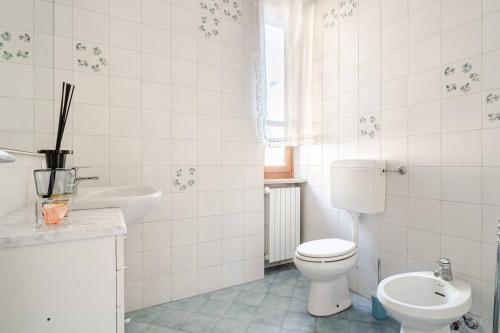 a white bathroom with a toilet and a sink at Le Terrazze di Cesy in Brescia
