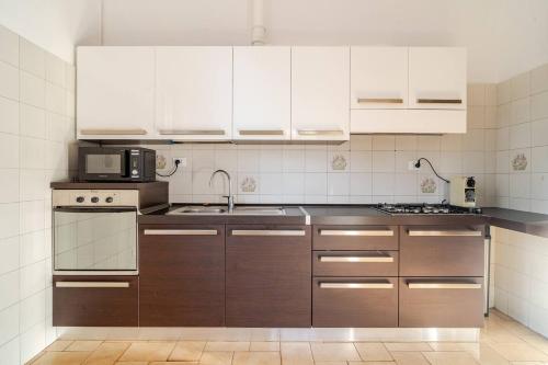 a kitchen with white cabinets and a microwave at Le Terrazze di Cesy in Brescia