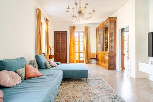 a living room with a blue couch and a chandelier at Le Terrazze di Cesy in Brescia