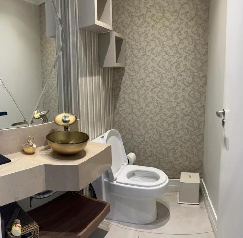 a bathroom with a toilet and a sink at Apto 3 Suítes e Garagem Dupla Itapema Meia Praia em Ótima Localização in Itapema