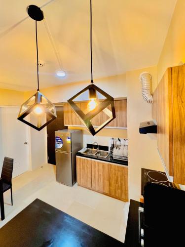a kitchen with wooden cabinets and stainless steel appliances at Avida Towers Atria in Iloilo City