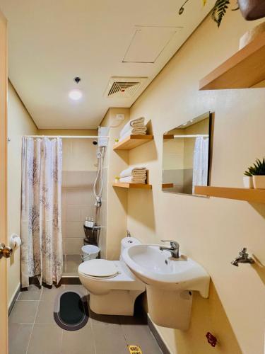 a bathroom with a toilet and a sink at Avida Towers Atria in Iloilo City