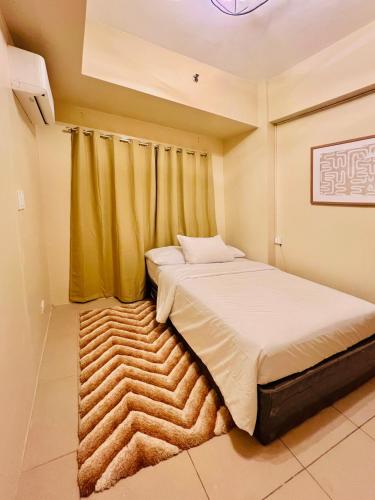 a bedroom with a bed and a rug at Avida Towers Atria in Iloilo City