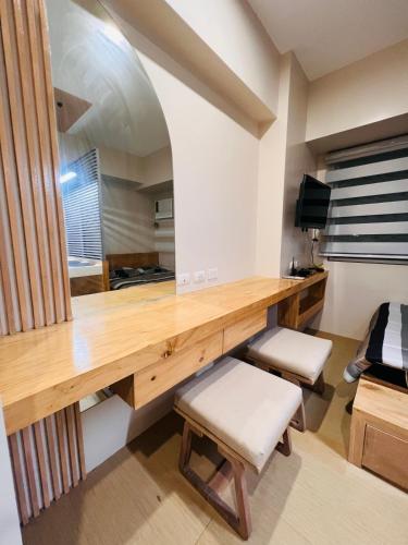 a room with a wooden desk and a mirror at Avida Towers Atria in Iloilo City