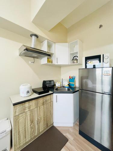a kitchen with a refrigerator and a sink at Avida Towers Atria in Iloilo City
