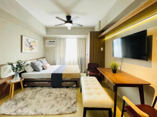 a bedroom with a bed and a flat screen tv at Avida Towers Atria in Iloilo City