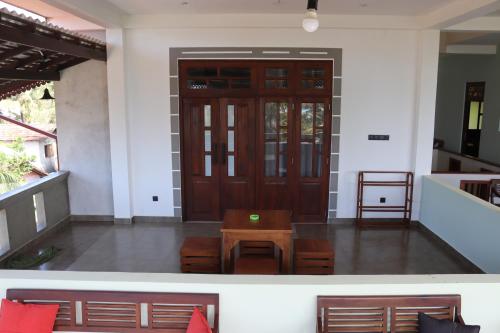 a front door of a house with a table and chairs at Plantation Surf Inn & Restaurant - Midigama in Midigama