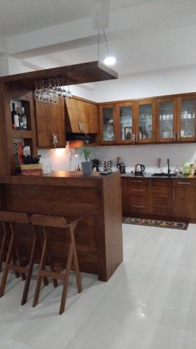 a kitchen with wooden cabinets and a large island at Serene Haven Villa in Batapola