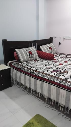 a bed with a black and white comforter and pillows at Serene Haven Villa in Batapola