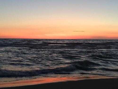 a view of the ocean at sunset with waves at Valamar Apartment Hamallaj in Draçi