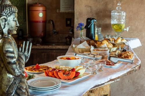 een buffet met eten op een tafel met borden bij Villa Buena Vista in Praia do Rosa
