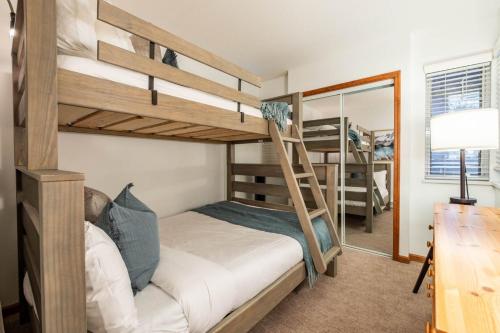 a bedroom with two bunk beds and a desk at Sunpath by Outpost Whistler in Whistler