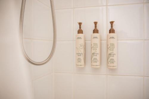 three shampoo bottles sitting on a shelf in a shower at Sunpath by Outpost Whistler in Whistler