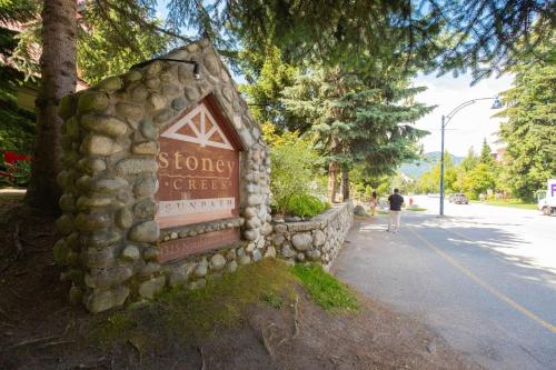 a stone wall with a sign on the side of a street at Sunpath by Outpost Whistler in Whistler