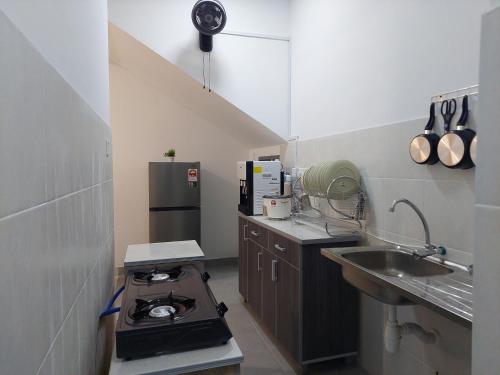 a small kitchen with a stove and a sink at Ammar Homestay Nilai in Nilai