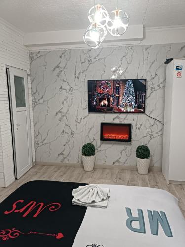 a living room with a fireplace and a christmas tree at Stan u centru 1 in Šid