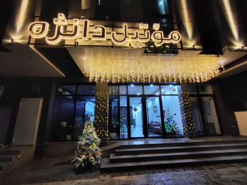 a christmas tree in front of a building at Danzha Motel Erbil in Erbil