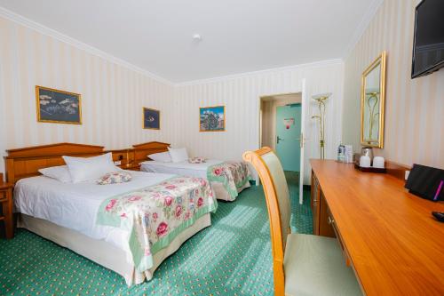 a hotel room with two beds and a television at Hotel am Schlosspark in Gotha