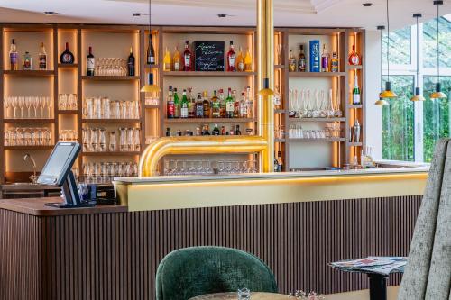 a bar in a restaurant with two green chairs at Hotel am Schlosspark in Gotha