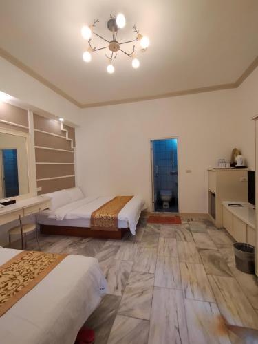 a bedroom with two beds and a chandelier at 陶陶居商旅 Tautauchu Hotel in Hualien City