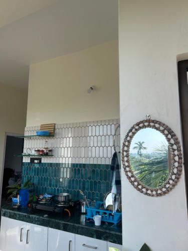 een keuken met een wastafel en een spiegel aan de muur bij Choudhury's Stay in Helāpākari