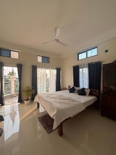 a bedroom with a large bed with blue curtains at Choudhury's Stay in Helāpākari