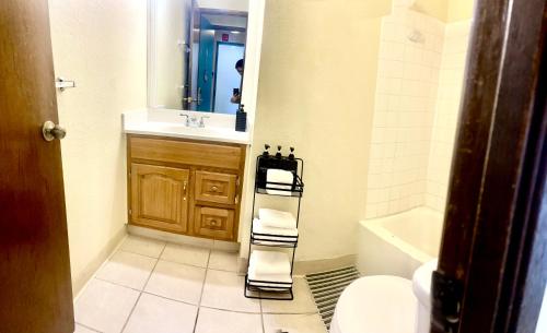 a bathroom with a sink and a toilet and a mirror at Ocean Canal Mountain View Steps from Waikiki Beach 6person in Honolulu