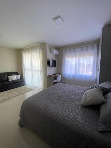 a bedroom with a large bed and a window at Loft central com garagem in Pelotas