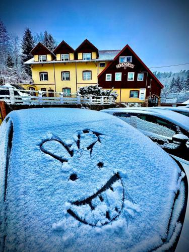 a car covered in snow with a smileydrawn on it at Harmont Montis- dawna Zającówka- IDEALNA lokalizacja - leśna enklawa w centrum miasta! Sauna, masaże, zabiegi spa! in Szklarska Poręba