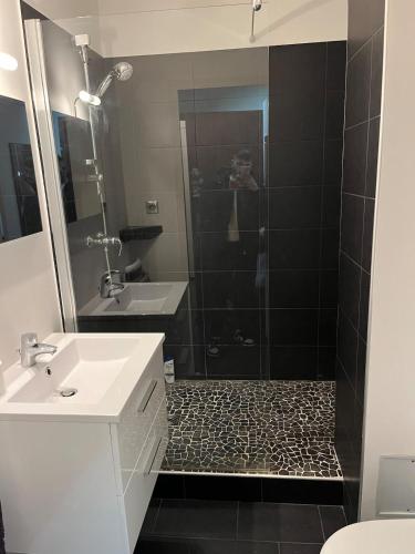 une salle de bain avec une douche, un lavabo et un miroir dans l'établissement Charmand studio auron, à Saint-Étienne-de-Tinée