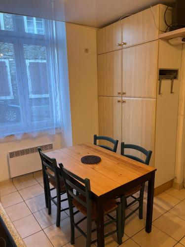 une table à manger avec des chaises et une armoire dans l'établissement Studio fonctionnel, à Eaux-Bonnes