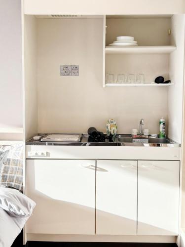 a kitchen with white cabinets and a sink at 浅草スカイガーデンホテル in Tokyo