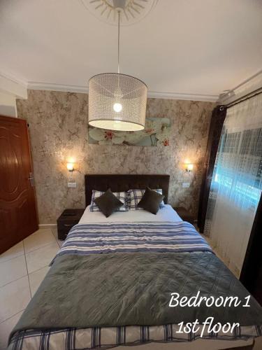 a bedroom with a bed and a chandelier at APARTMENT AYOUB -for families only- in Nador