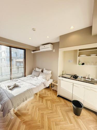 a bedroom with a large bed and a kitchen at 浅草スカイガーデンホテル in Tokyo