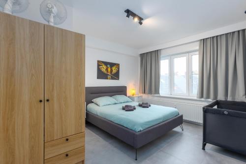 オーステンデにあるOstend Center Luxury Top Floor Apartment with Free Parkingのベッドルーム1室(ベッド1台、キャビネット、窓付)