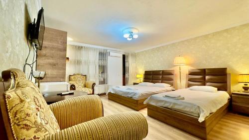 a hotel room with two beds and a couch at Old city Apartment 1 in Tbilisi City