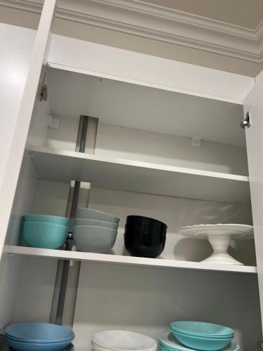 a shelf with bowls and other dishes in a kitchen at Velvet Vouge Hostel in Yerevan