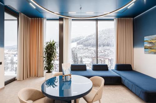 a living room with a blue couch and a table at Tavel Hotel & SPA in Bukovel