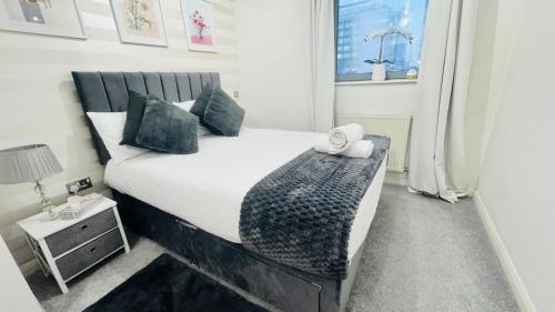 a bedroom with a large bed with a night stand at Entire Apartment next to Canary Wharf in London in London