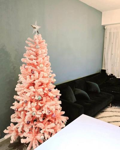 a pink christmas tree in a living room at Lakeland Apartments in Rovaniemi