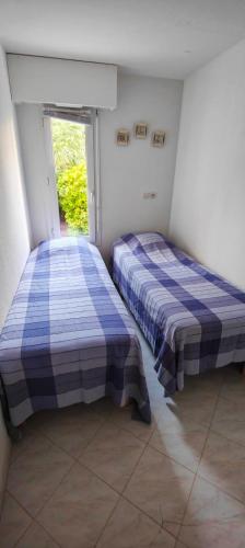 deux lits dans une chambre avec une fenêtre dans l'établissement T2 150m from the beach, à Fréjus